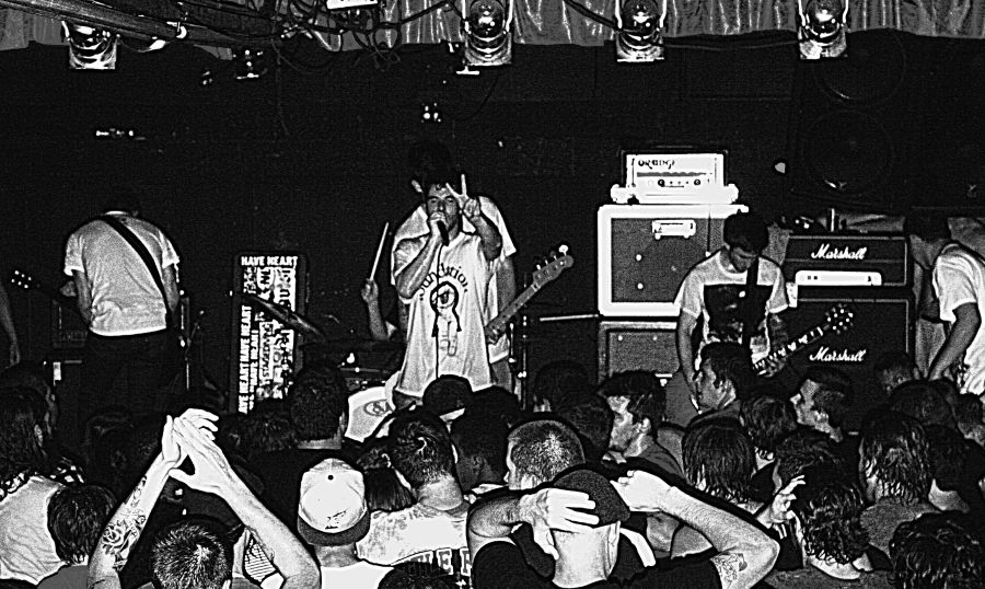 Black and white photo of Have Heart performing onstage, crowd visible in foreground